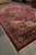 Corner perspective of oversize hand-knotted wool rug showing black main border and ivory rosettes