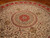 10' x 10' round silk rug close-up showing ivory field, red starburst center and scrolling vines