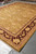 Length view of 12' x 15'2" hand-knotted Agra rug showing gold guard border and fringe