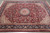 9 x 12 Oriental rug photographed flat on grey tile showing burgundy field and navy floral border