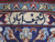 Woven signature cartouche in ivory and navy within the border of this signed Persian rug