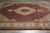 Wide view of the fish pattern field, ivory medallion and floral ivory border with olive guard stripes