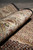 Rolled edge showing the lustrous wool and silk pile across the ivory main border