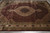 Angled overhead view highlighting the beige center medallion and ivory floral main border of the rug