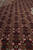 Deep ruby red field close-up showing fine knotting, diamond lattice and small ivory leaves