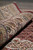 Rolled edge showing the lustrous wool and silk pile depth and layered border stripes