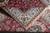 Folded corner revealing ivory fringe, fine weave and the crisp border drawing of this rug