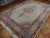 9'8" x 13'4" Tabriz rug at an angle, coral border and deep blue guard stripes visible