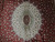 Close-up of ivory medallion, sage green ring and small burgundy cartouche with fine floral vines