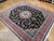 Angled view of hand-knotted wool and silk Tabriz rug showing sheen across black floral field
