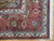 Corner detail showing dusty rose border, ivory guard stripes, green palmettes and white cotton fringe