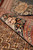 Rolled edge close-up showing plush wool and silk pile across rust and ivory guard stripes