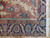 Corner detail of navy main border, salmon rosette cartouches, sage guard stripe and white fringe