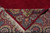 Folded corner revealing cotton foundation, ivory fringe and the reverse of the floral border