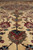 Low angle showing dense pile, burgundy palmettes and delicate vine scroll across ivory ground
