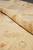 13'8" x 13'11" square rug rolled back to reveal pile depth and natural wool luster