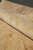 Rolled edge showing plush natural wool pile depth and soft peach and gold flower motifs