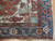 Corner detail showing indigo main border, rosette chain and ivory guard stripes on antique wool pile