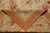 Folded corner showing flat weave reverse, plain brown outer border and loose weft tails behind