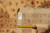 Back of the rug with tag reading 13.1 x 16.2 beside a tape measure