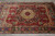 Angled floor view showing ivory center medallion, navy cartouche and salmon spandrels on red field