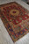 Collectible 6'5" x 9'10" Persian Tabriz rug shown at an angle in the showroom