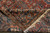 Folded corner showing the back of the antique Persian wool rug and cotton fringe