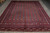 Full floor view of the hand-knotted Bokhara showing rows of octagonal guls on indigo ground