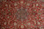 Centre medallion detail showing navy 8 petal rosette framed by pink tracery on red ground