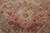 Close view of ivory medallion with pale green petals over peach pink floral field