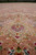 Low angle across the pink field toward the pale green and ivory center medallion