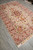 6'7" x 10'3" Persian Tabriz wool and silk rug angled on grey floor showing rose border