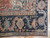 Corner detail of indigo border with rosettes, salmon vines and hand-knotted wool selvedge edge
