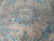 Antique Persian floral medallion photographed close, showing navy petals, blush taupe ground and soft blue vinework