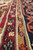 Angled macro of red and camel guard borders showing dense wool pile and knotting