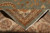 Back of the 12' x 12' square rug folded to reveal hand-knotted weave and fringe