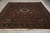 Wide floor view showing black main border and all-over floral field on hand-knotted wool