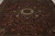 Close overhead of cream medallion, burgundy ground and olive green blossoms on Indian rug