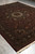 9' x 11'10" hand-knotted rug seen lengthwise on grey floor with fringe ends
