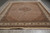 Angled full view of large 10x14 wool and silk Mahi rug on concrete floor