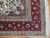 Border detail showing burgundy palmettes, beige guard stripe, sage green spandrel and ivory hand-tied fringe