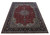 Angled view of oversize hand-knotted wool Isfahan design rug showing deep navy floral borders
