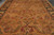 Close field detail of large gold palmettes drawn in crimson, olive green and coral