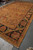 Angled corner view showing black border, olive guard stripe and hand-knotted cotton fringe ends