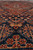 Detail of indigo field showing red flowering shrubs, ivory rosettes and low antique wool pile
