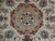 Close-up of the layered blue, coral and ivory medallion with red rosette garland and palmettes