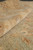Rolled edge detail showing plush hand-spun wool pile in gold and soft green tones