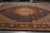 Black ground Tabriz fish design rug laid flat showing camel spandrels and dark floral border