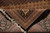 Folded corner revealing dense weave, black selvedge and cotton fringe of this hand-knotted Persian rug