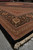 Low angle view of oversize 12x17 living room rug showing deep black border and fringe